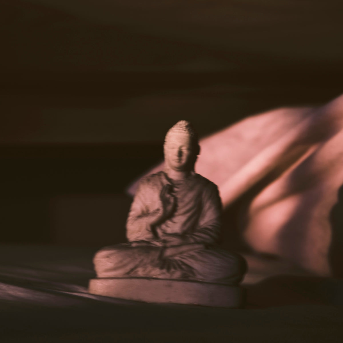 man in brown robe sitting on rock formation during night time