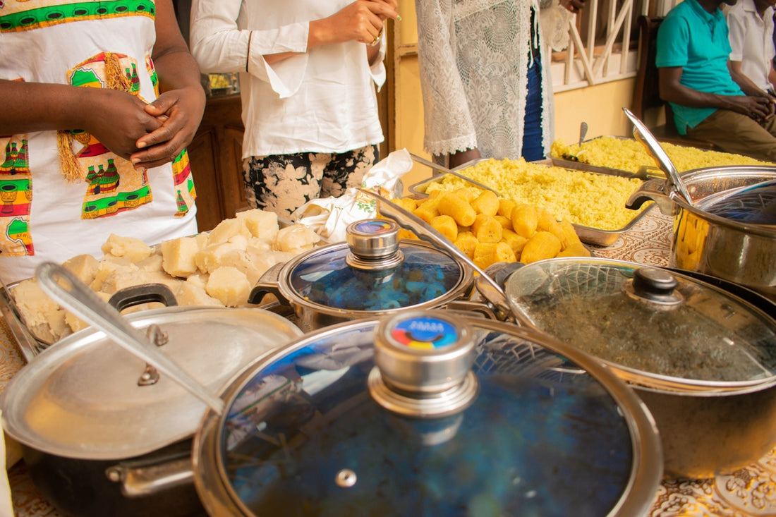 a group of people standing around a table full of food
