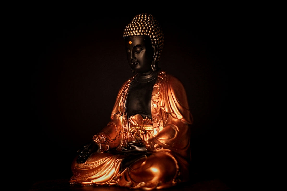 a golden buddha statue sitting in the dark