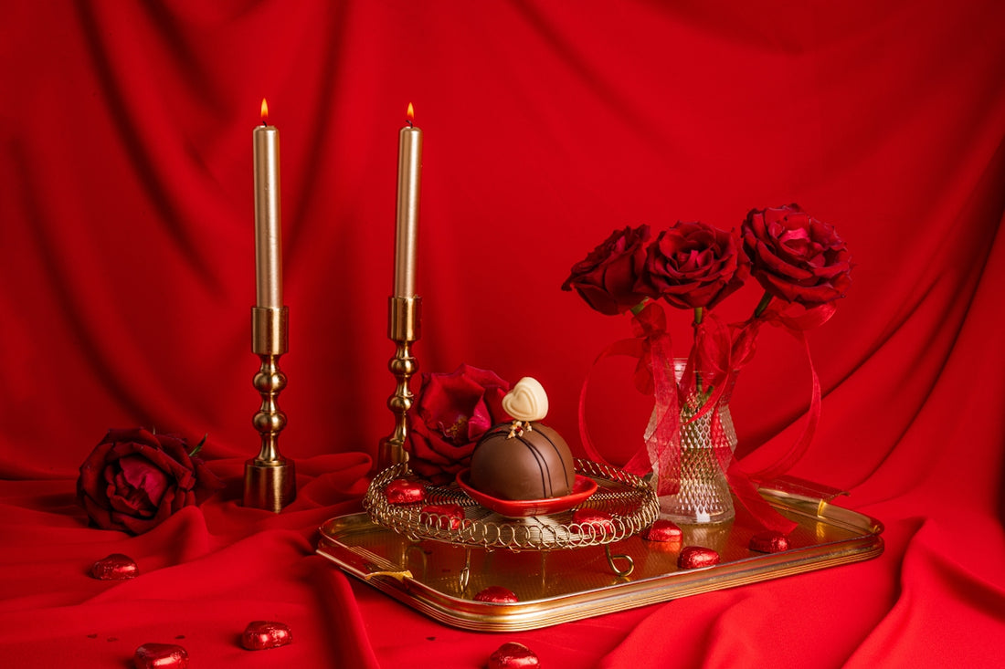 a table topped with a tray covered in chocolates and roses