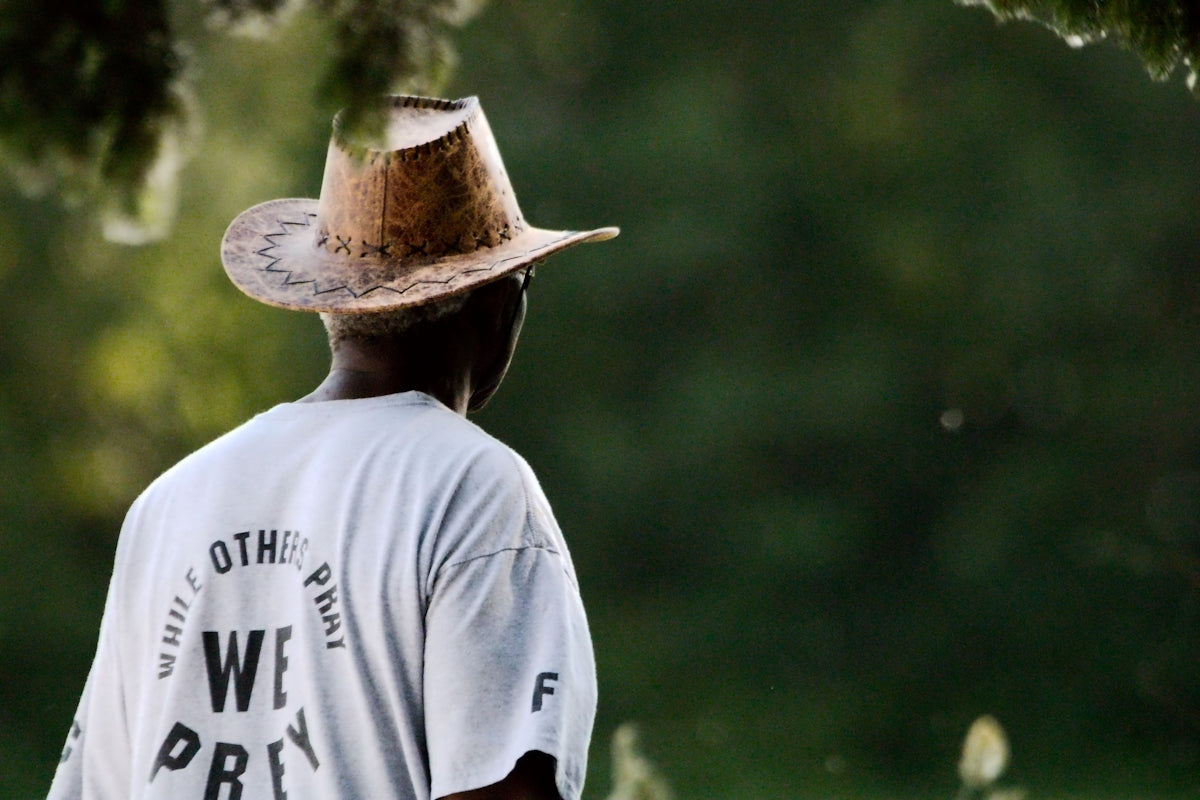 a man wearing a cowboy hat standing in a field