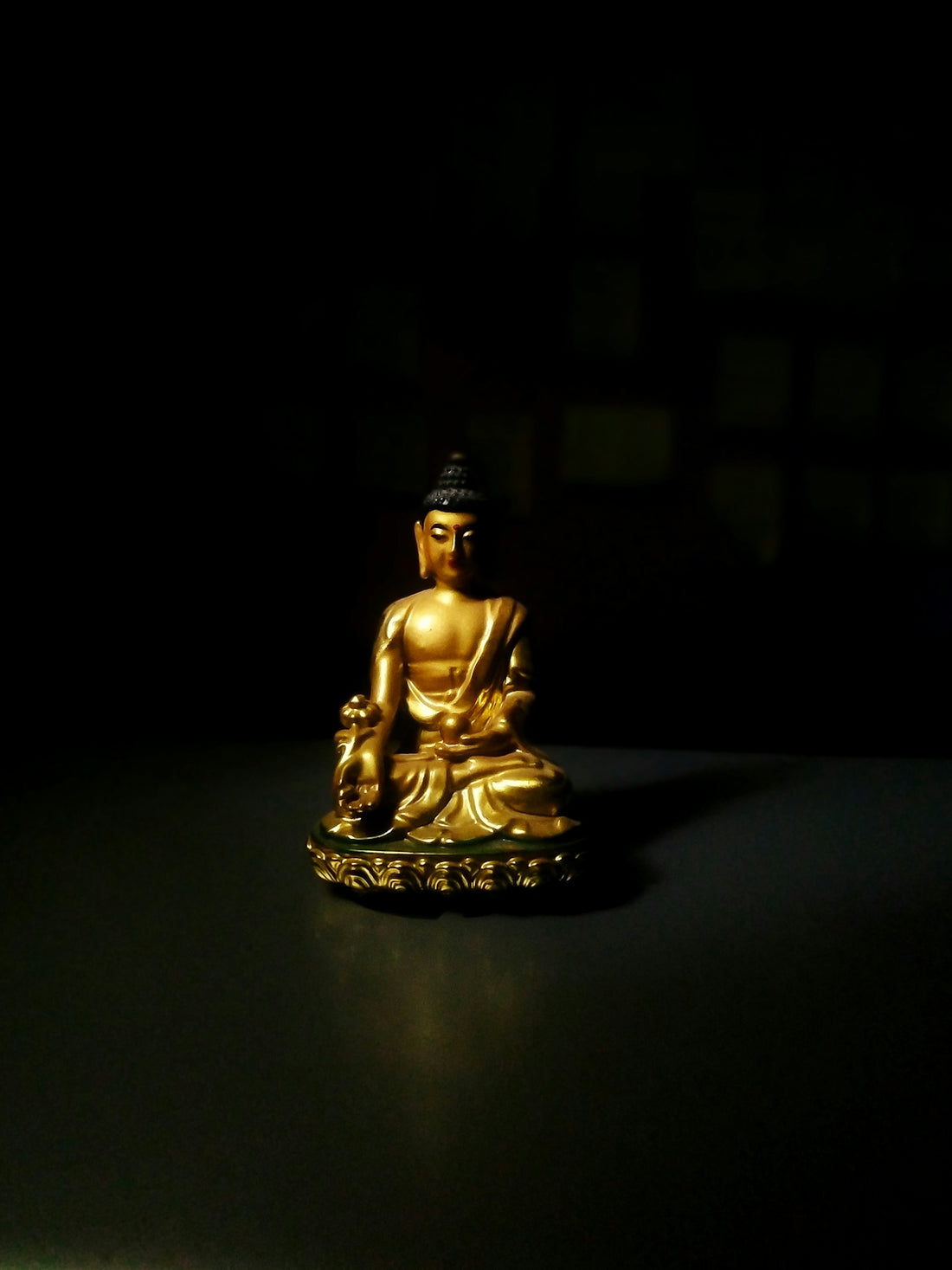 A golden buddha statue sitting on top of a table
