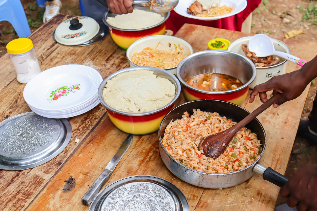 A wooden table topped with bowls and pans filled with food