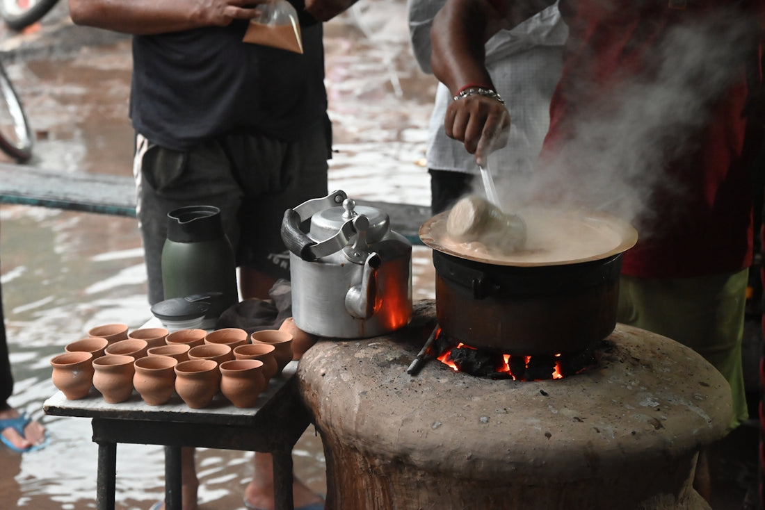 A man standing next to a woman cooking food on top of a stove