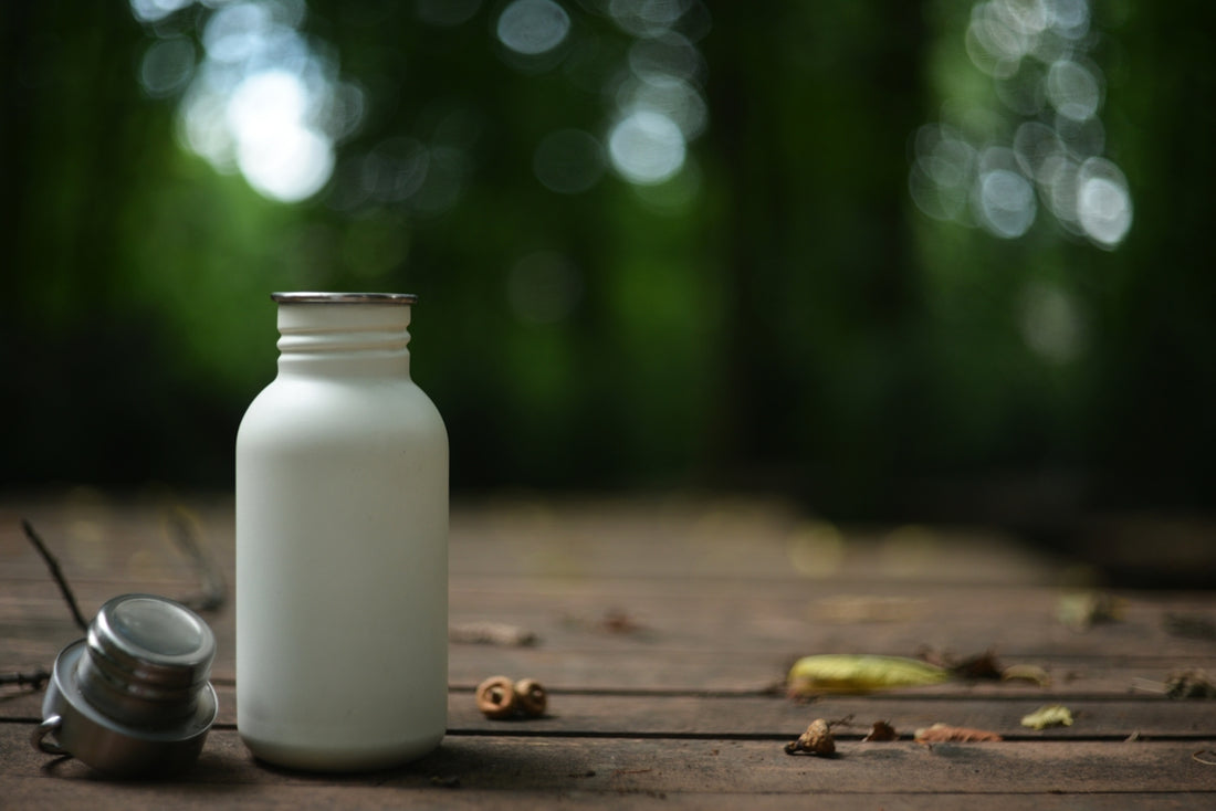 White water bottle rests on a wooden surface.